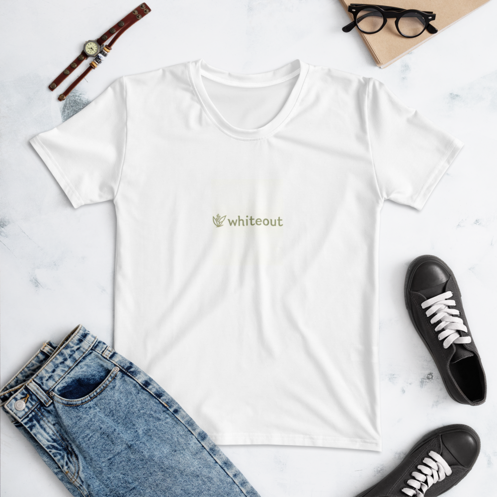 White t-shirt with 'whiteout' logo on a marble surface with jeans and sneakers.