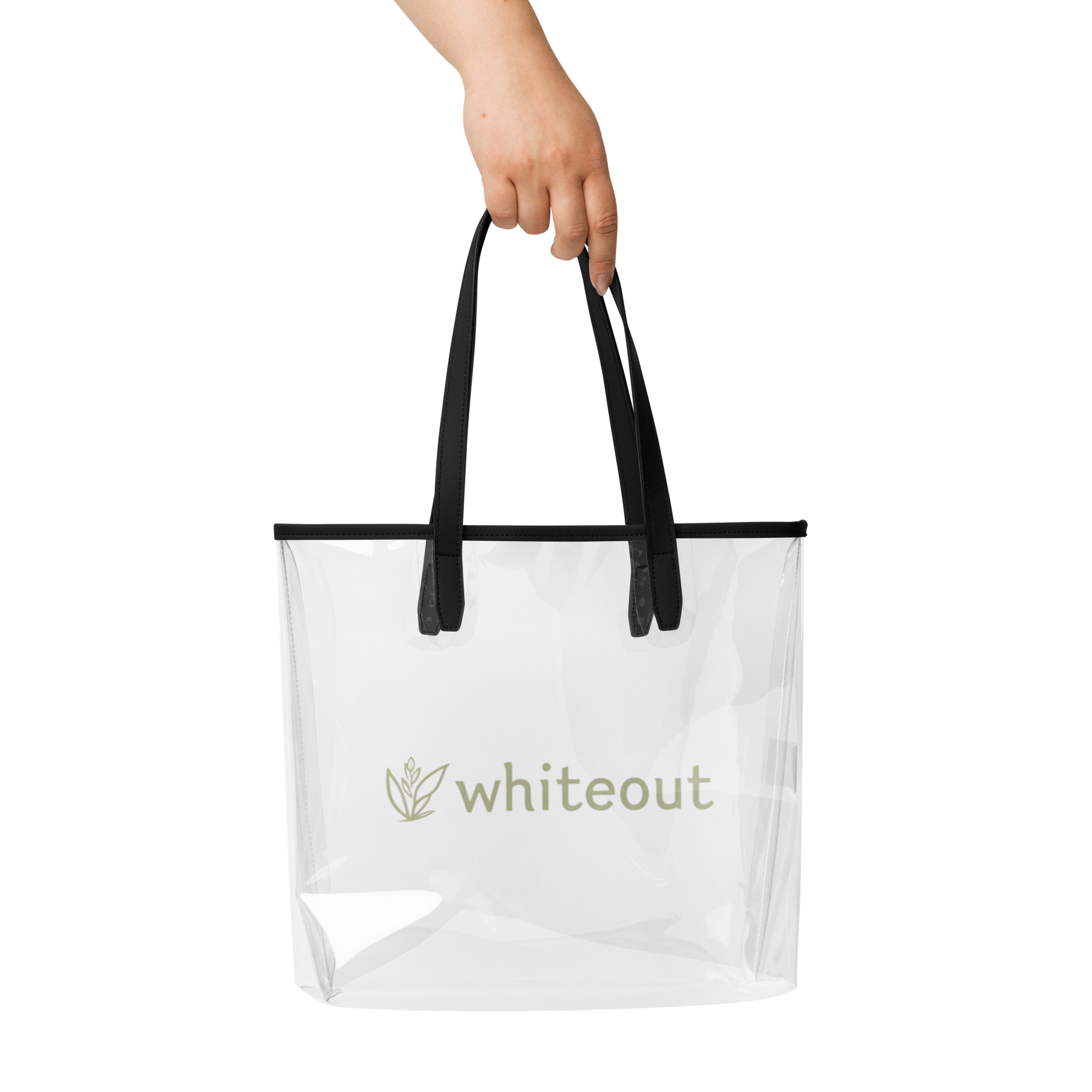 Clear tote bag with black handles held by a hand on a white background, featuring the brand 'whiteout'.