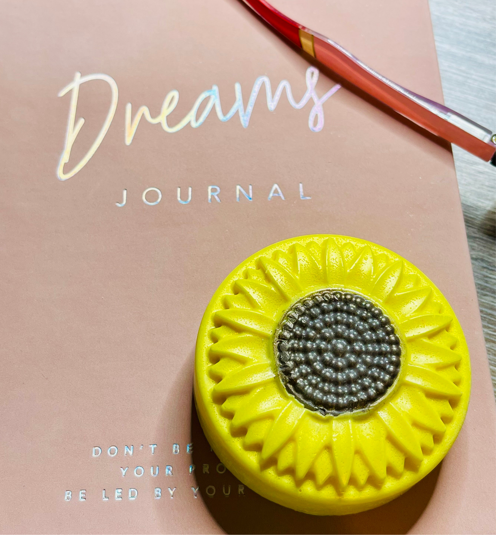 Journal with a yellow sunflower design and text on a light pink background