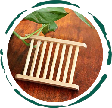 Wooden soap dish on a wooden surface with green leaves