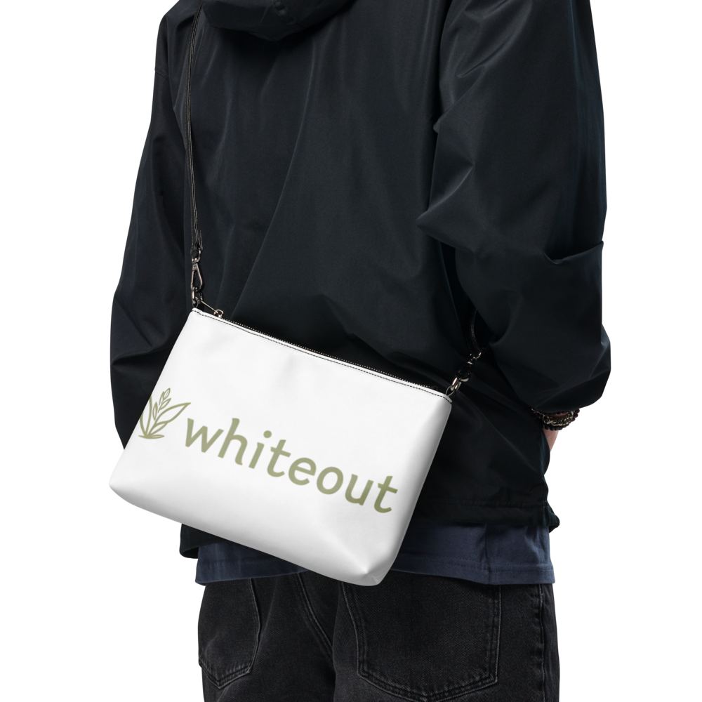 Person wearing a black jacket with a white bag featuring 'whiteout' branding.