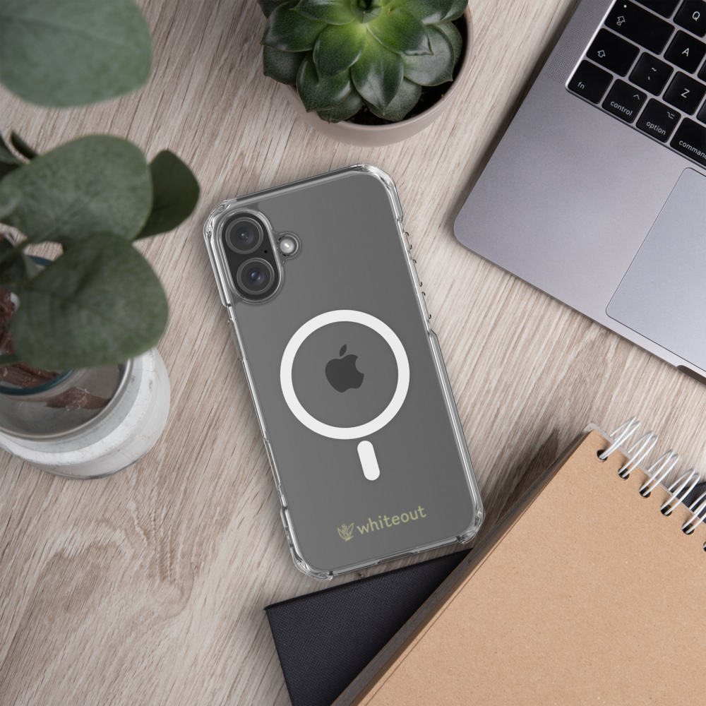 Phone case with Apple logo on a desk with laptop, notebook, and plants
