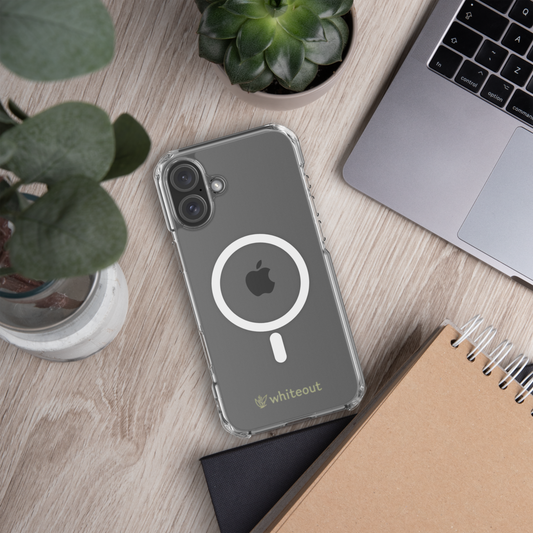 Phone case with Apple logo on a desk with laptop, notebook, and plants