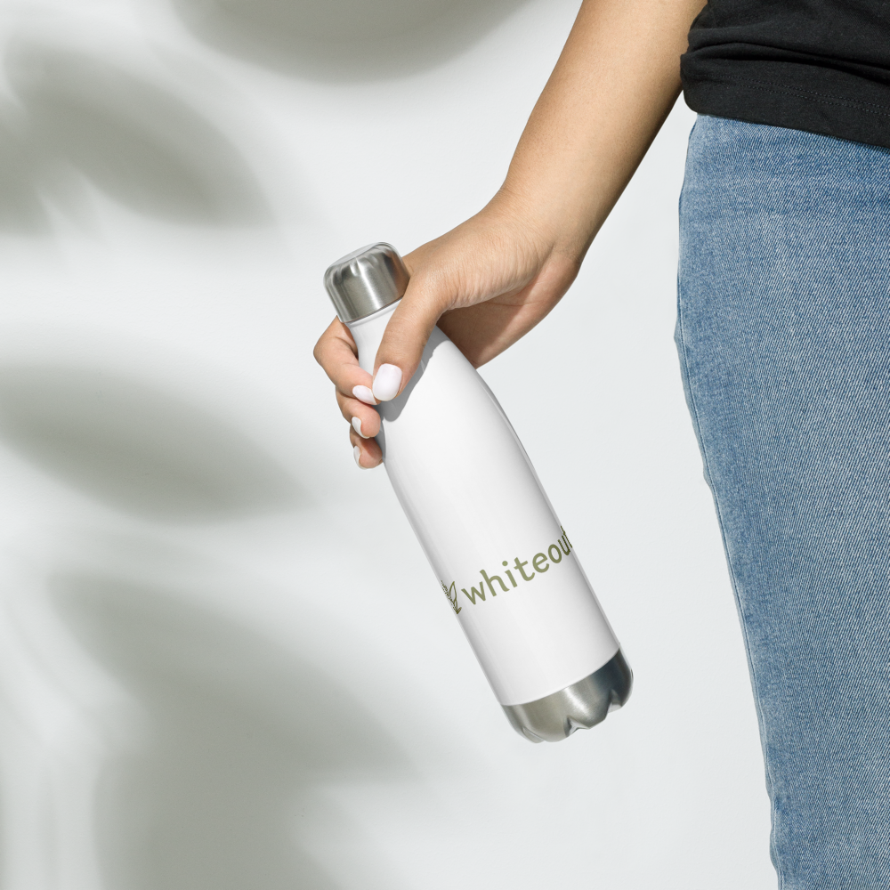 Person holding a white water bottle with 'whiteout' branding on a light background