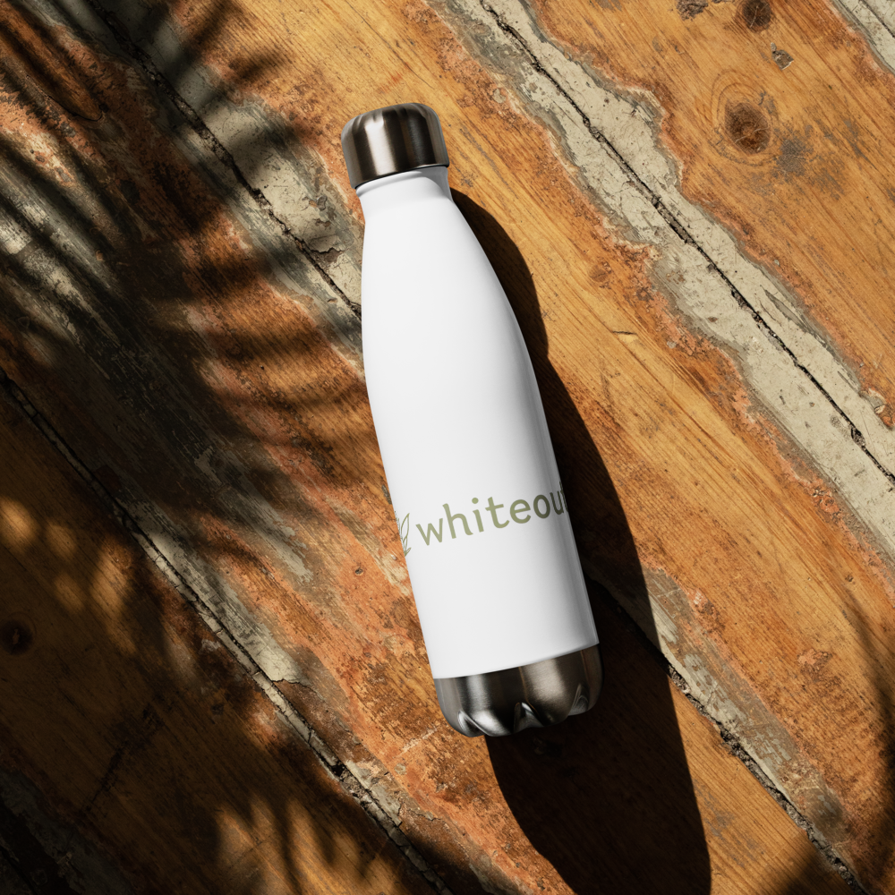 White water bottle with 'whiteout' branding on a wooden surface